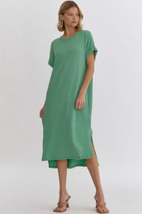 Ribbed short sleeve midi dress featuring slit at side hem. Unlined. Knit. Non-sheer. Lightweight.